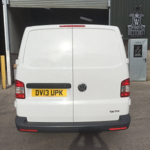 white vw camper entering garage