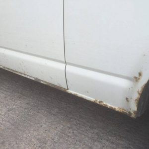 rust on exterior of white camper van