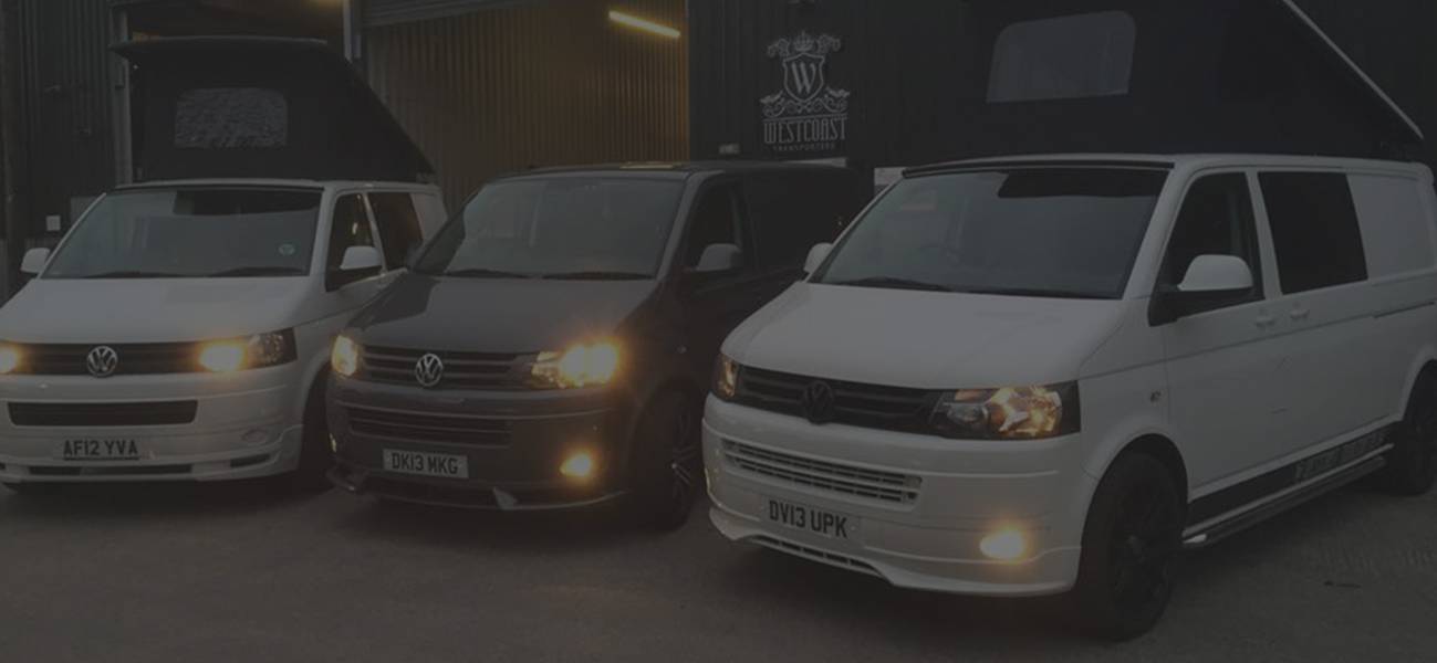 t5 vans lined up outside garage