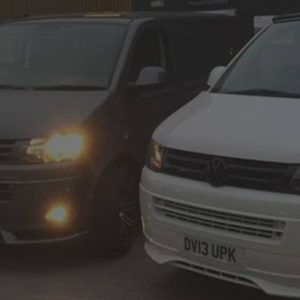 t5 vans lined up outside garage